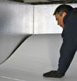 contractor installing TerraBlock™ floor insulation in a Blaine crawl space