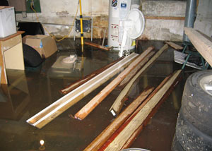 A severely flooding basement in Blaine, with lumber and personal items floating in a foot of water