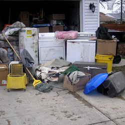Soaked, wet personal items sitting in a driveway, including a washer and dryer in Coon Rapids.