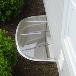 A vinyl basement window and covered window well in Chaska